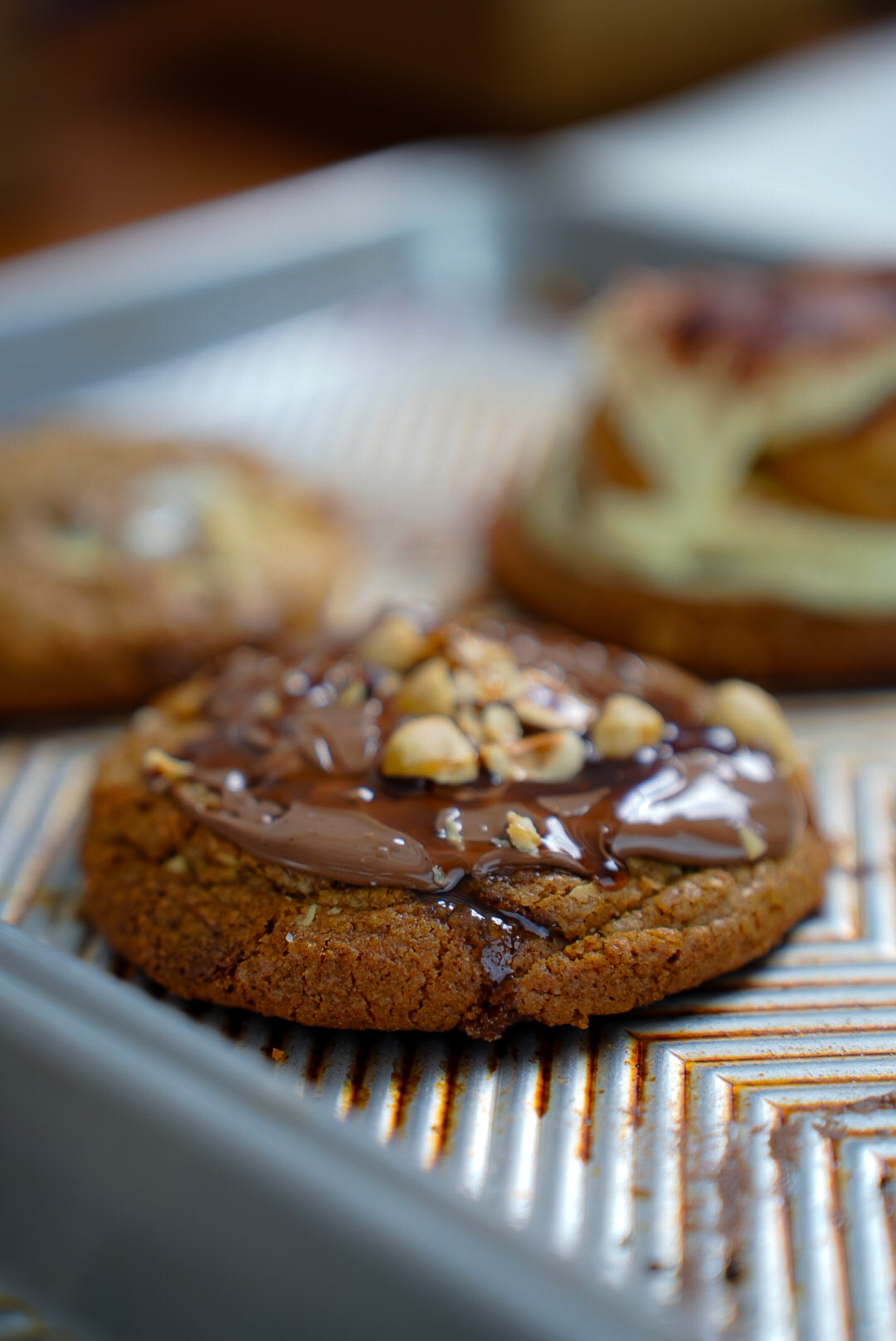 Close-up of a fresh Batch69 chocolate hazelnut cookie on a baking tray